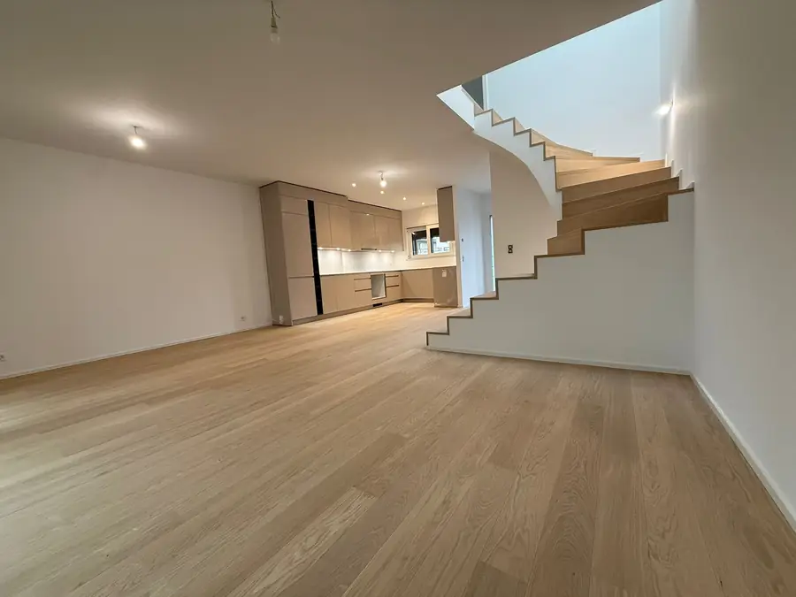 Séjour rénové avec parquet en chêne et escalier bois, finitions intérieures réalisées par H Bat Sàrl